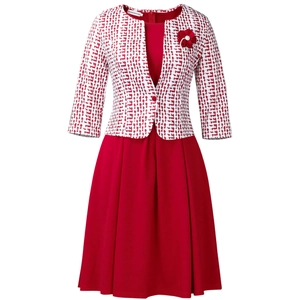 Détail d'une robe rouge plissée avec cardigan à imprimé géométrique et broche fleur