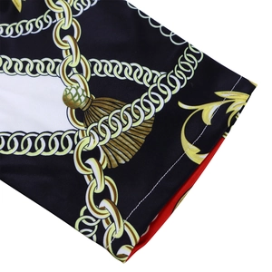 Détail de la manche à imprimé baroque avec motifs de chaînes dorées et doublure rouge