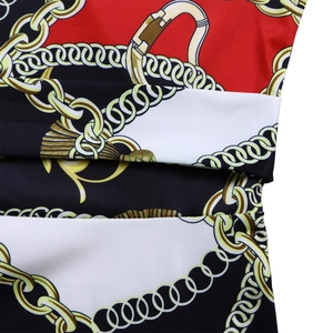 Détail du motif baroque vintage avec chaînes dorées sur tissu rouge et noir