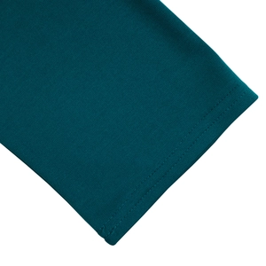 Detail of fine knit fabric in dark teal with neat double-needle stitching on the hemline