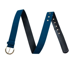 Vue détaillée d'une ceinture en tissu bleu foncé avec boucle dorée ronde et œillets