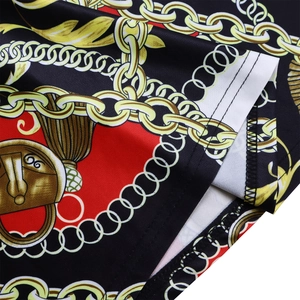 Détail macro de l'imprimé chaîne dorée et pompon sur l'ourlet en tissu noir et rouge