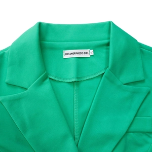 Detail view of bright green blazer collar with white brand label and twill fabric texture