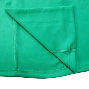 Detailed close-up of precise overlock stitching on the hem of a green blazer dress