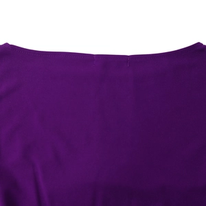Dettaglio dello scollo a barca e delle cuciture su un abito a pieghe viola