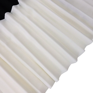 Macro shot of vertical accordion pleats on white polyester fabric for a pleated dress