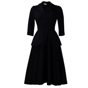 Détail du col à revers et de l'étiquette sur une robe noire à manches 3/4 évasée
