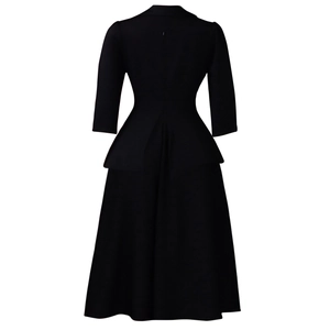 Vue arrière d'une robe midi noire avec taille ajustée et fermeture éclair invisible