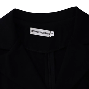 Vue détaillée du col d'une veste noire avec étiquette de marque METAMORPHOSIS GIRL taille S