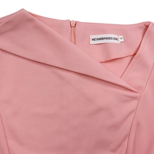 Detail of pink dress neck with asymmetrical design, invisible zipper, and woven label