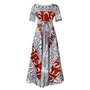 Détails de la taille haute nouée et de l'imprimé religieux sur cette robe évasée rouge