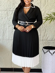 Elegant black and white pleated A-line dress with long sleeves and gold buckle belt