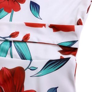 Gros plan d'une robe blanche à fleurs rouges et feuilles bleues avec coutures précises