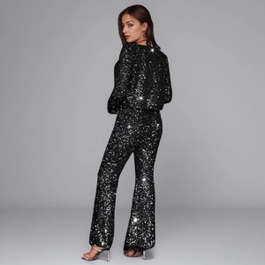 Sparkly black sequin two-piece set featuring long sleeve crop top and flared pants