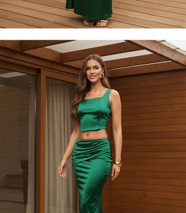 Detail of elegant dark green satin two-piece set featuring backless top and high waist skirt