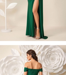 Detail of emerald green off-shoulder evening gown featuring high slit and satin texture
