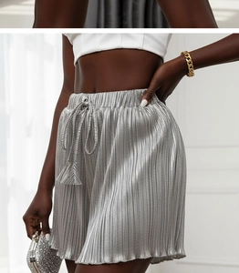 Detail view of silver metallic pleated high waist shorts with drawstring elastic waistband