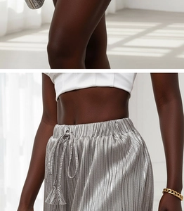 Detailed macro view of silver metallic pleated high waist shorts with drawstring texture