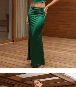 Detail of elegant dark green satin maxi skirt featuring waist pleats and side slit