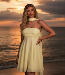Détail de la robe en mousseline jaune clair avec plis fins et écharpe assortie