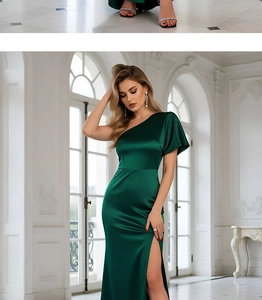Detail of dark green satin one-shoulder evening gown with high slit and elegant draping