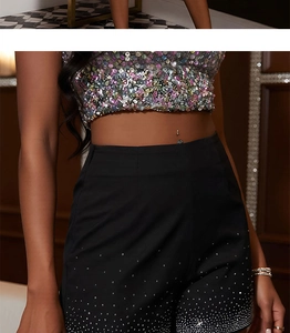 Détail du short noir taille haute avec des ornements en paillettes argentées