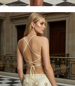 Dettaglio delle eleganti spalline incrociate e paillettes dorate sull'abito beige