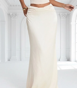 Détail de la taille plissée sur une jupe longue de soirée en satin beige à taille haute
