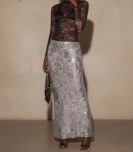 Detailed view of silver sequin fabric and texture on a long slim fit party skirt