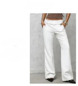Detail view of white high-waisted wide-leg trousers featuring decorative waist buttons