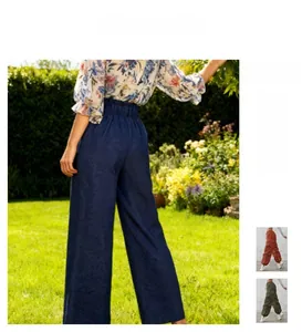 Detail of high-waisted wide-leg pants featuring subtle textured patterns and side pockets