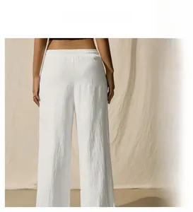 Detail of high-waist wide-leg pants with drawstring and pleated fabric texture