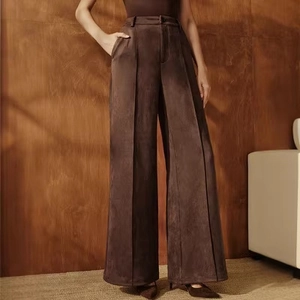 Detail view of high waist dark brown suede wide leg trousers with textured pleats