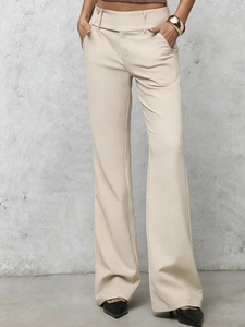 Detailed close-up of high-waisted beige trousers featuring side buckles and side pockets