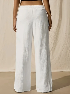 Back view of women's white high waist wide leg trousers with elastic waistband and soft texture
