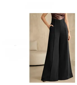 Detail view of high waist wide leg pants featuring vertical seams and smooth drape