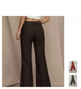 Detailed view of high waisted flared brown trousers with drape fabric and belt loops