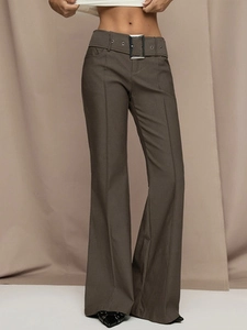 Detail of high-waist flared pants featuring wide belt with silver metal buckle and front pleats