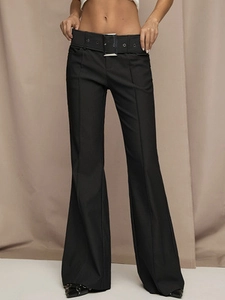 Detail of black wide-leg trousers featuring a wide belt and large silver metal buckle