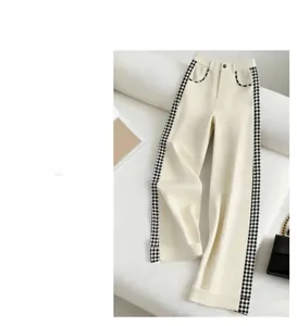 Détail du pantalon crème à taille haute avec coutures pied-de-poule sur les poches