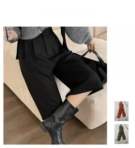 Detail of high waist black wide leg trousers with double pleats and tailored suit fabric