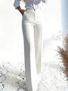 Elegant high waisted white wide leg trousers with sharp creases and flowing fabric drape