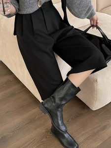 High waist wide leg black trousers featuring elegant pleats and modern cropped silhouette