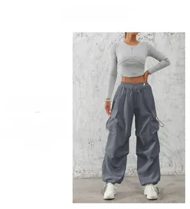 Detail of grey ribbed long sleeve crop top with zipper and cargo pants with side pockets