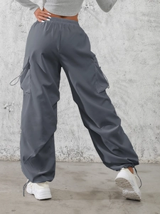 Women's charcoal grey cargo parachute pants with functional pockets and drawstring cuffs