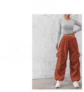 Dettaglio dei pantaloni cargo con grandi tasche laterali e coulisse in vita rosso mattone
