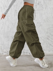 Detail of olive green cargo pants featuring adjustable drawstring pockets and elastic waistband