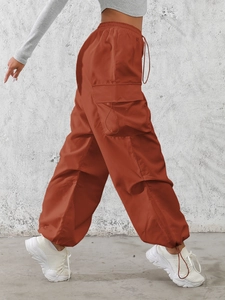 Pantaloni cargo da donna rosso mattone a vita alta con tasche a patta e fondo con coulisse