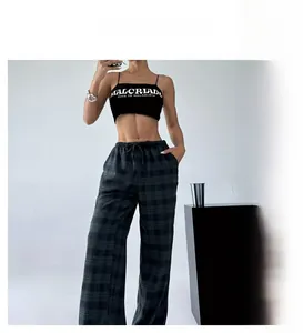 Detail view of high-waisted plaid wide-leg pants featuring elastic drawstring waist and pockets