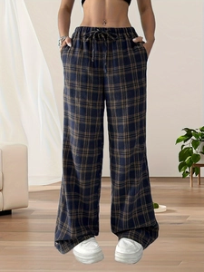Women high waisted plaid wide leg trousers with elastic drawstring in home setting